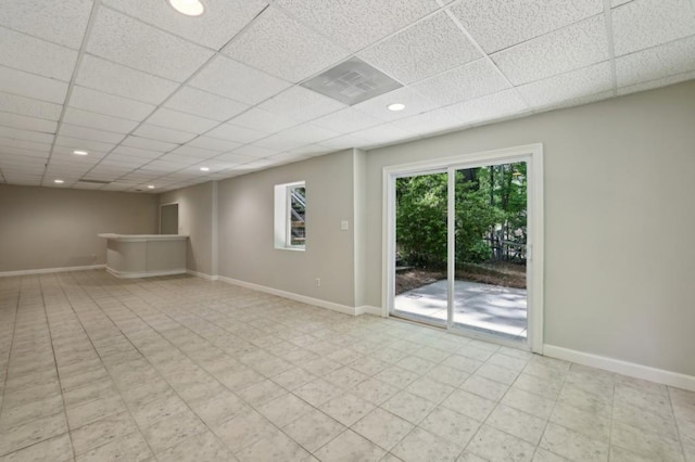 unfurnished room with baseboards, a drop ceiling, and recessed lighting