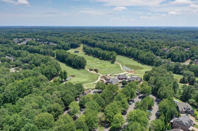 drone / aerial view of a heavily wooded area and a golf club