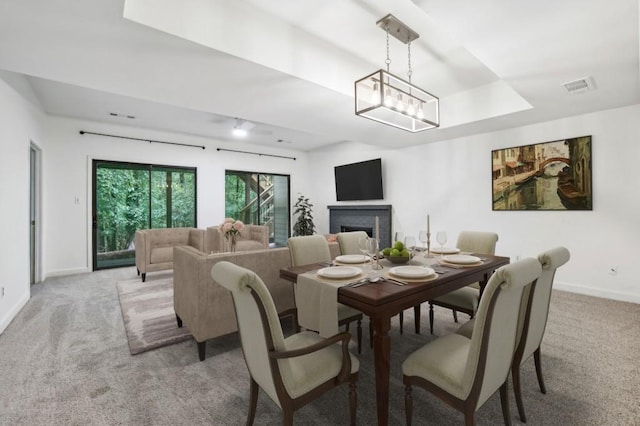 dining area with light carpet, baseboards, and a fireplace