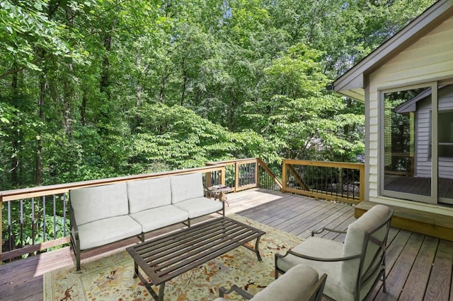 wooden terrace featuring outdoor lounge area and a view of trees