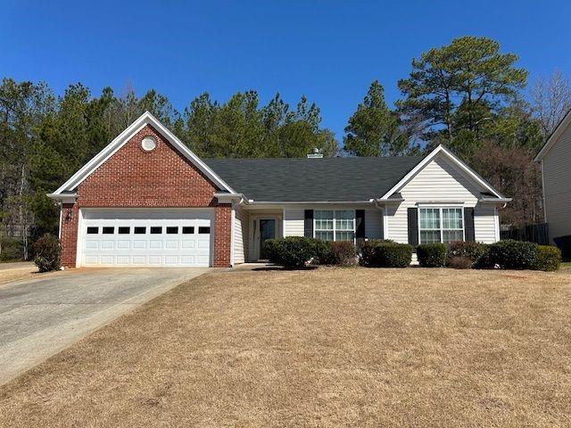 ranch-style home featuring brick siding, driveway, and an attached garage