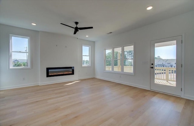 1919 Deco Dr, Kennesaw, GA 30144 - unfurnished living room featuring a ceiling fan, light wood finished floors, a glass covered fireplace, and recessed lighting