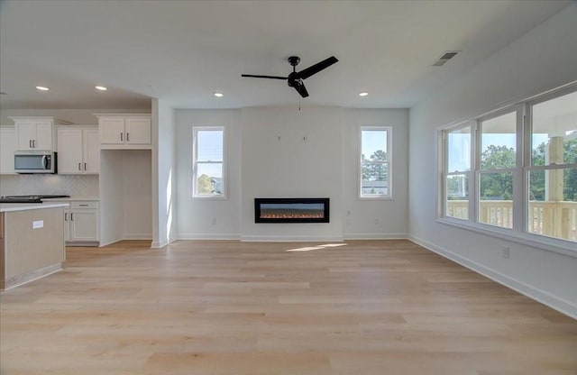 1919 Deco Dr, Kennesaw, GA 30144 - unfurnished living room featuring a ceiling fan, a glass covered fireplace, light wood-style flooring, and recessed lighting