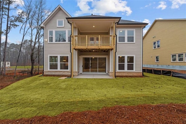 rear view of house with a yard, a balcony, and a patio area