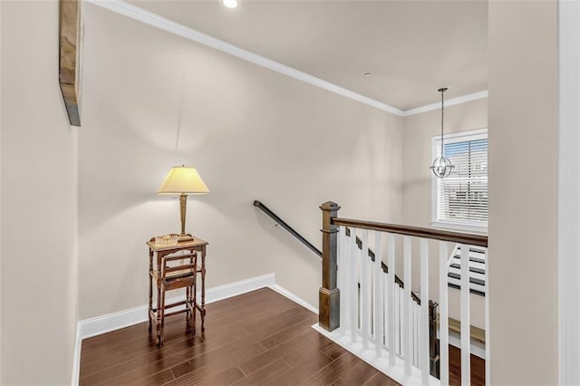 stairway featuring a notable chandelier, crown molding, and wood-type flooring