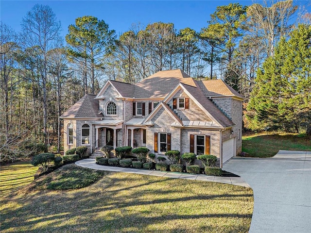 view of front of property featuring a front yard, concrete driveway, and brick siding