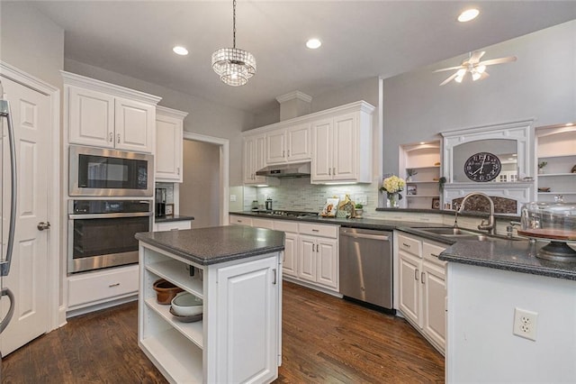 kitchen featuring stainless steel appliances, dark countertops, and white cabinetry