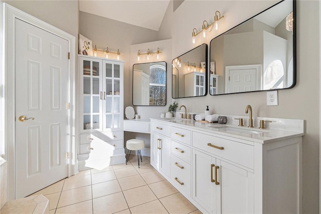 bathroom featuring lofted ceiling, double vanity, a sink, and tile patterned floors