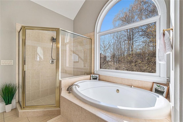 bathroom featuring a relaxing tiled tub, a stall shower, vaulted ceiling, and tile patterned floors