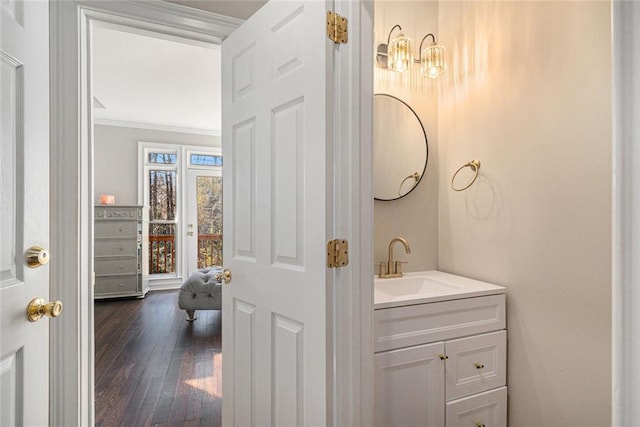 bathroom with ornamental molding, vanity, and wood finished floors