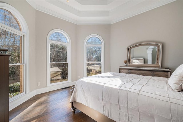 bedroom featuring crown molding, visible vents, a raised ceiling, and dark wood-style flooring