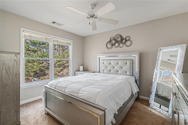 bedroom featuring ceiling fan, dark colored carpet, visible vents, and baseboards