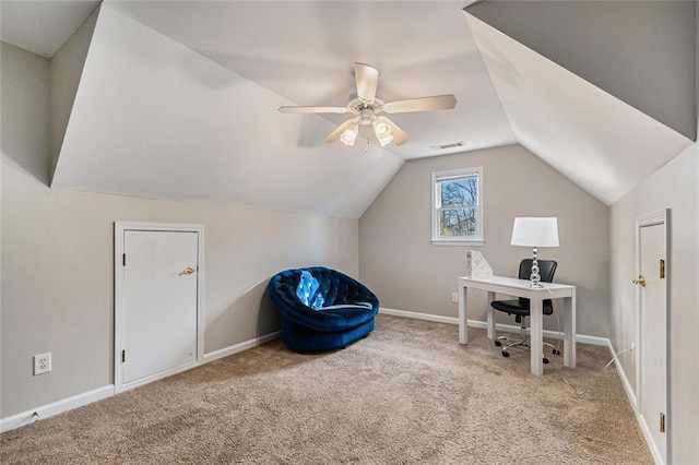 office space with baseboards, visible vents, vaulted ceiling, and light colored carpet