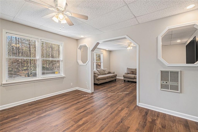 unfurnished room featuring a healthy amount of sunlight, baseboards, dark wood finished floors, and a ceiling fan