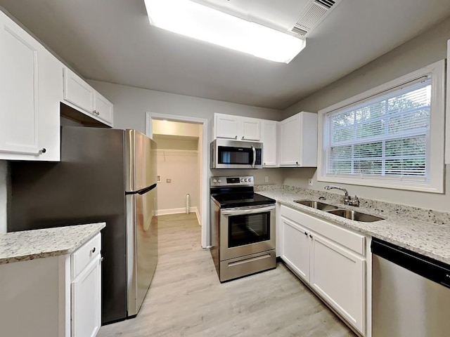 1232 Pinedale Cir NW, Conyers, GA 30012 - kitchen featuring stainless steel appliances, a sink, light wood-style floors, and white cabinets