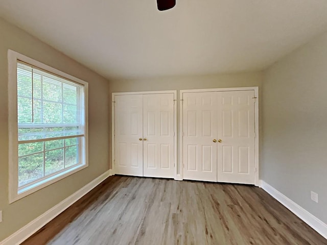 1232 Pinedale Cir NW, Conyers, GA 30012 - unfurnished bedroom with multiple closets, wood finished floors, and baseboards