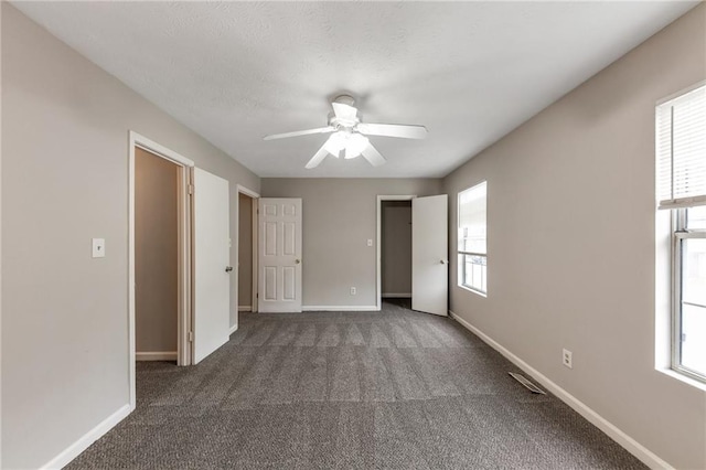8541 Westchester Dr, Douglasville, GA 30134 - unfurnished bedroom featuring multiple windows, dark colored carpet, baseboards, and a ceiling fan