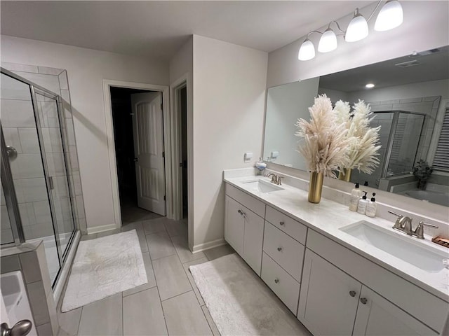 full bathroom featuring a sink, baseboards, double vanity, and a shower stall