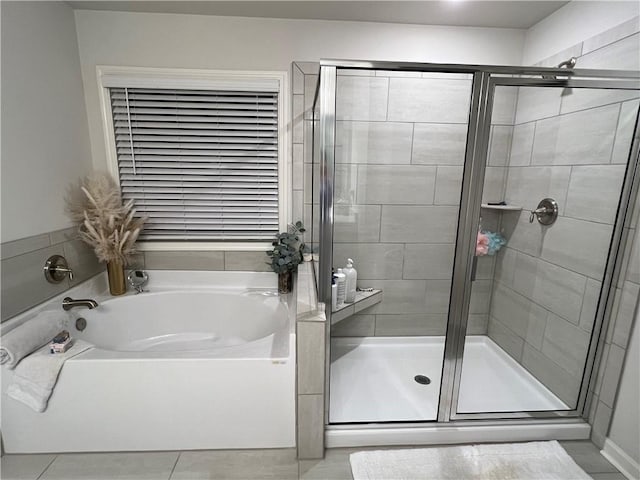 full bathroom featuring a shower stall and a bath