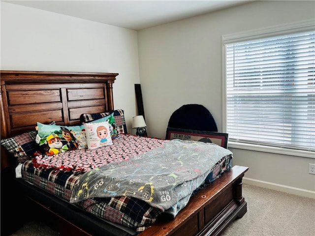 bedroom featuring light colored carpet and baseboards