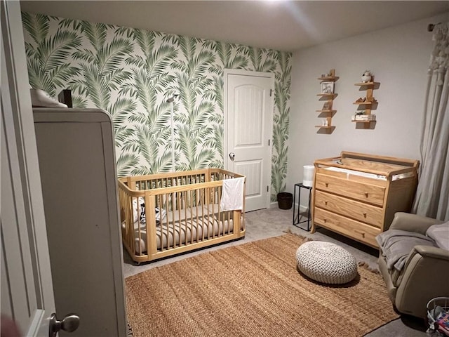 bedroom featuring wallpapered walls, a crib, and carpet floors