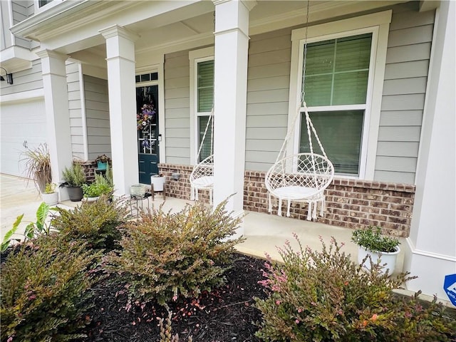 entrance to property with brick siding and a porch