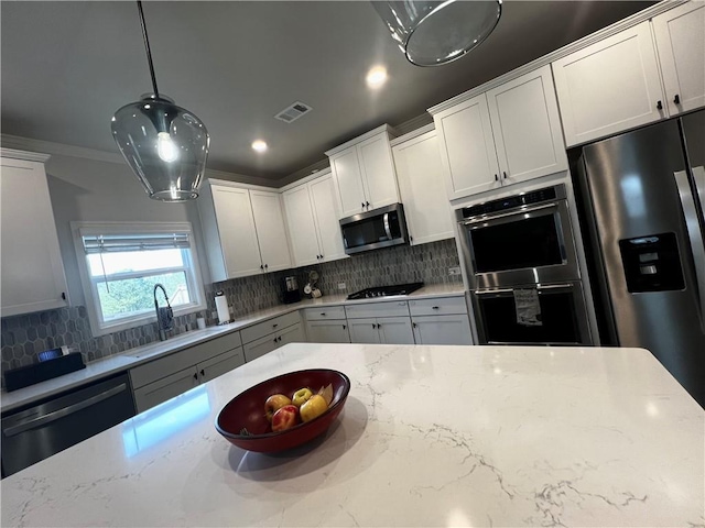 kitchen featuring a sink, stainless steel appliances, backsplash, and visible vents