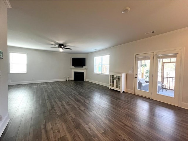 unfurnished living room with visible vents, dark wood-type flooring, baseboards, ceiling fan, and a fireplace