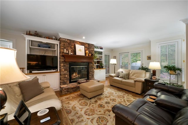 living room with ornamental molding, light wood-type flooring, and a fireplace