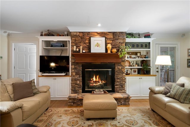 living room featuring crown molding, a fireplace, and light wood-type flooring