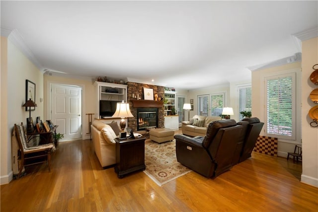 living room featuring a large fireplace, ornamental molding, and wood-type flooring