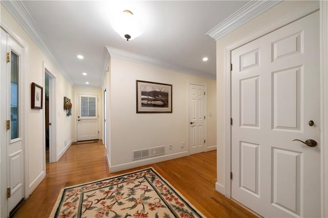 hall with light hardwood / wood-style flooring and ornamental molding