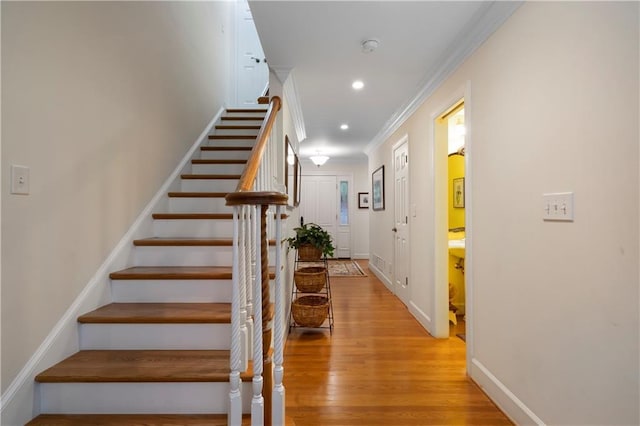 stairway featuring hardwood / wood-style floors and ornamental molding