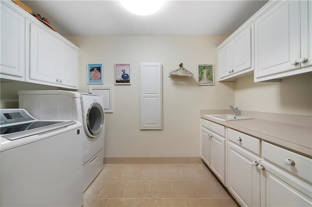 washroom with cabinets, washer and clothes dryer, sink, and light tile patterned floors