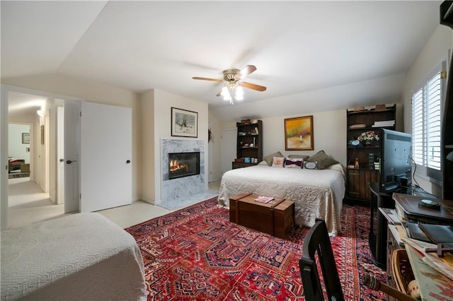 bedroom with lofted ceiling, a fireplace, and ceiling fan