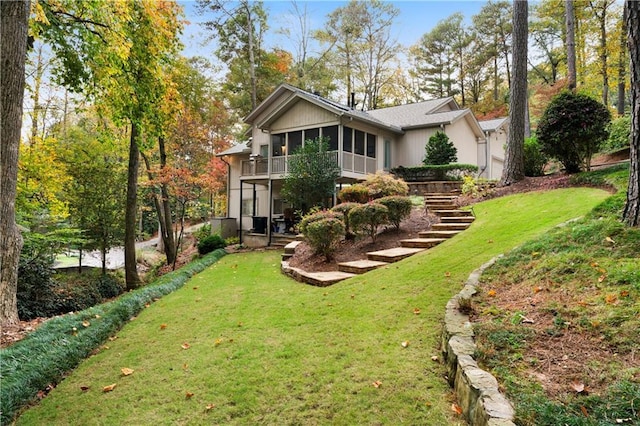 rear view of property with a sunroom and a yard