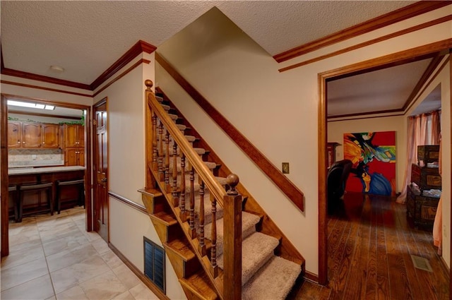 stairway featuring a textured ceiling