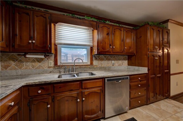 kitchen with light stone counters, stainless steel dishwasher, tasteful backsplash, light tile patterned flooring, and sink