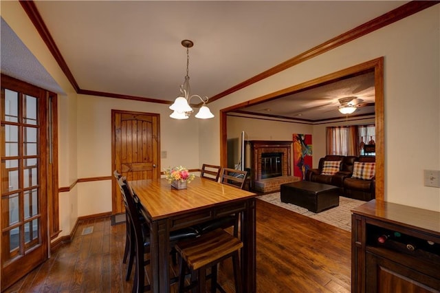 dining area featuring dark hardwood / wood-style flooring, an inviting chandelier, and crown molding