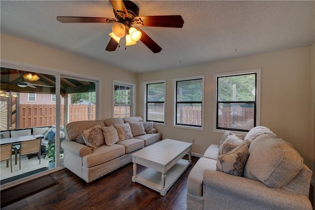 living room with dark hardwood / wood-style flooring, a textured ceiling, and ceiling fan