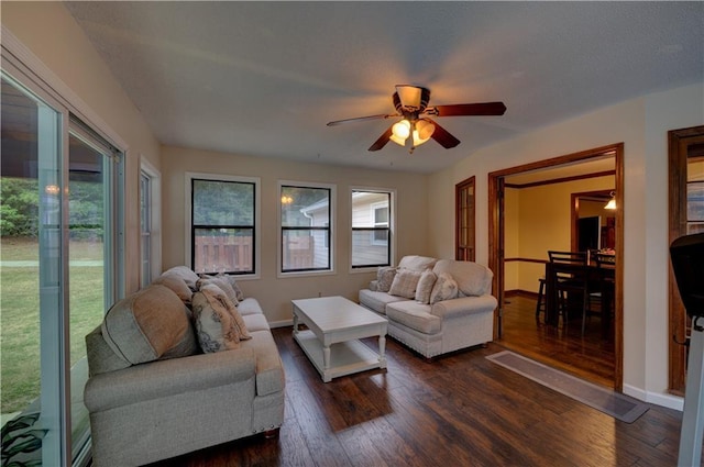 living room featuring ceiling fan and dark hardwood / wood-style floors