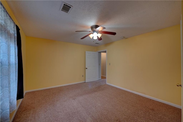 empty room featuring a textured ceiling, ceiling fan, and carpet