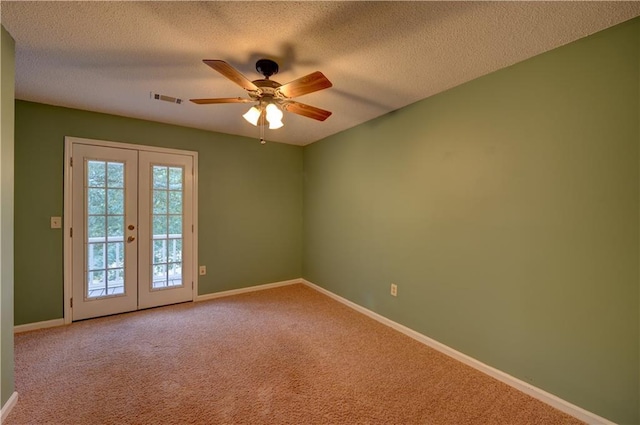 carpeted empty room featuring ceiling fan, french doors, and a textured ceiling