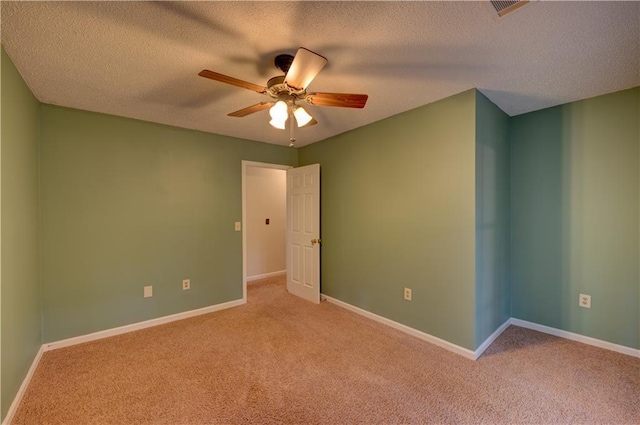 carpeted spare room with ceiling fan and a textured ceiling