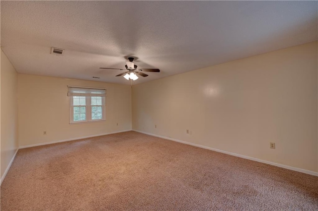 unfurnished room featuring ceiling fan, carpet floors, and a textured ceiling