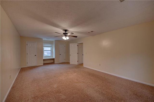 unfurnished room featuring ceiling fan, light carpet, and a textured ceiling