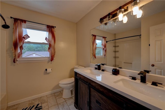 bathroom with toilet, a shower, vanity, and a wealth of natural light