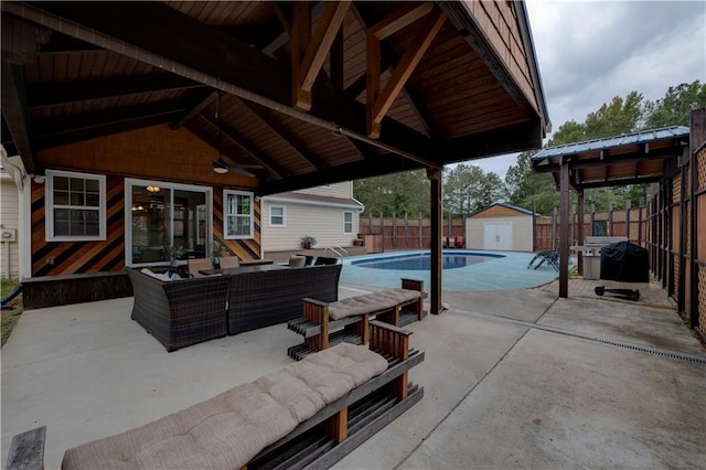 view of patio / terrace featuring an outdoor hangout area, a shed, a gazebo, area for grilling, and a fenced in pool