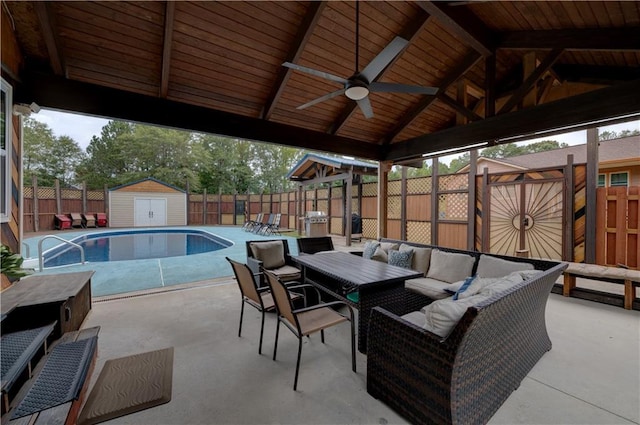 view of patio featuring a fenced in pool, ceiling fan, a shed, and outdoor lounge area