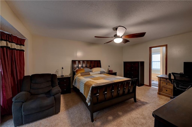 carpeted bedroom featuring ceiling fan, ensuite bath, and a textured ceiling